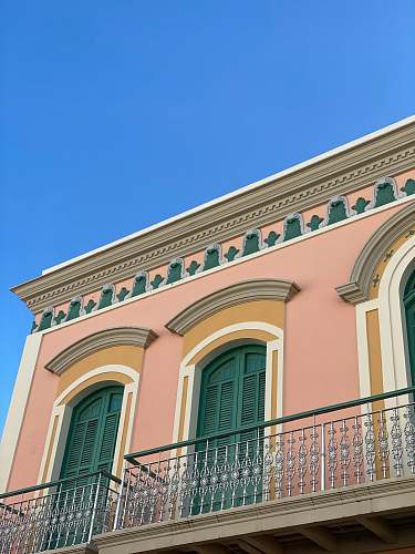 window pink and green concrete building under blue sky curtain